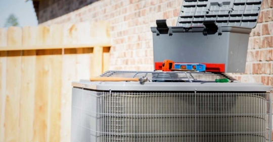 Air conditioning unit by a brick wall outside