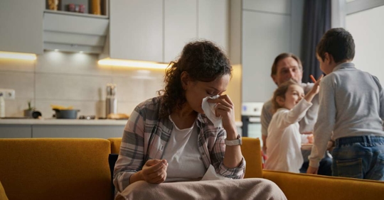 woman blowing her nose into napkin