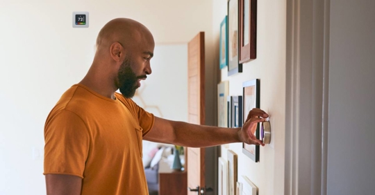 person adjusting thermostat